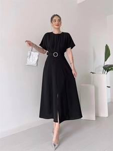 Detail of black midi dress with waist belt, silver buckle and front leg slit feature