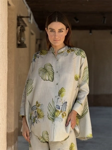 Detailed close-up of textured cotton linen set featuring green tropical leaf patterns