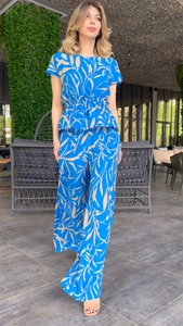 Detail of bright blue tropical print two-piece set featuring flutter sleeve top and wide pants