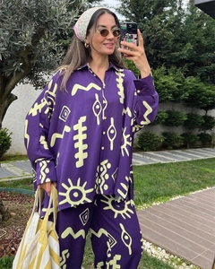 Detail of purple two-piece set featuring yellow abstract prints and relaxed wide-leg pants