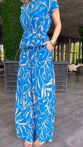 Detail of floral printed top with cinched waist and wide leg pants with pockets