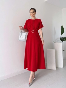 Detail view of a long red A-line dress featuring a waist belt with a silver round buckle