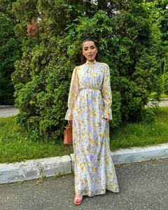 Détail de robe longue fleurie en mousseline avec col montant et poignets à volants chic