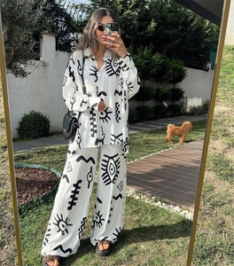 Detail view of stylish two-piece set featuring abstract print shirt and wide-leg trousers