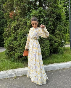 Détail d'une robe longue en mousseline fleurie avec manches lanternes et taille nouée