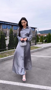 Detail of silver satin two-piece set featuring a silky long sleeve shirt and high waist skirt