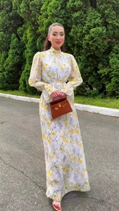 Détail de robe longue fleurie en mousseline avec col montant et taille cintrée