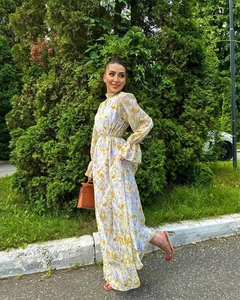 Détail d'une robe en mousseline fleurie avec motifs jaunes et poignets à volants