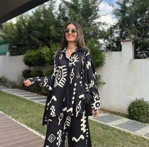 Close-up of black two-piece set featuring white abstract eye prints on fabric