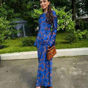 Elegant long sleeve maxi dress with bold blue and tan floral prints and cinched waistline