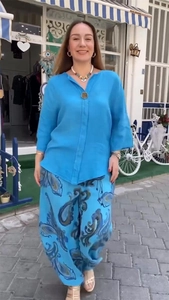 Détail de l'ensemble en lin bleu ciel avec chemise col V et pantalon imprimé paisley