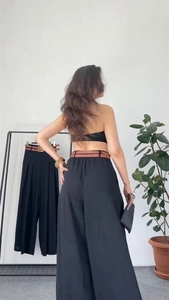 Detail view of high waisted wide leg trousers with elastic back and decorative belt