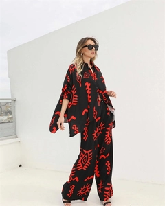 Detail of loose fit shirt and wide leg trousers with red abstract geometric patterns