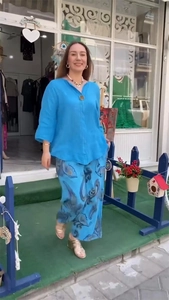Détail d'un haut en lin bleu roi à col en V et d'un pantalon large à motif floral en ville