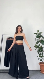 Close-up of high-waist wide-leg trousers with an elastic back waist and brown belt detail