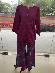 Détail du haut violet à col en V et du pantalon imprimé ethnique sur mannequin de magasin