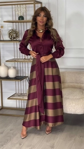 Détail de la taille nouée et de la jupe plissée à rayures bordeaux sur la robe longue