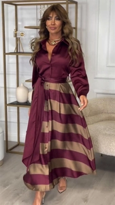 Détail d'une robe chemise en satin bordeaux avec jupe rayée et ceinture montrant le tissu