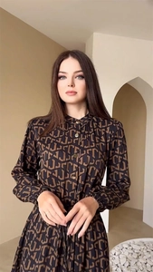 Detail view of monogram print dress featuring stand collar and metal button accents