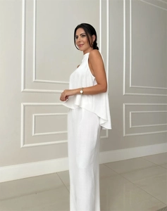 Detail of white sleeveless top with tiered ruffled hem and matching wide leg pants