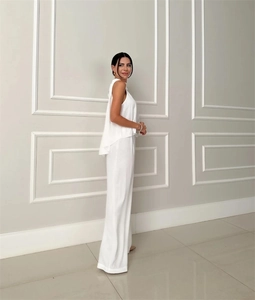 Detail of white sleeveless top and high-waisted wide-leg trousers set with drape texture