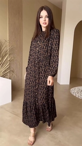 Detail of elegant coffee-colored dress with geometric print and waist tie detail