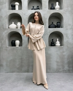 Dettaglio completo beige a due pezzi con maniche a campana e bottoni decorativi fini