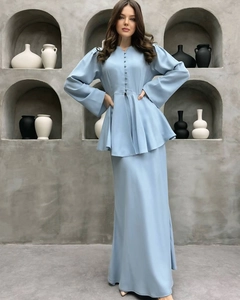 Dettaglio di un set azzurro due pezzi con top peplum e bottoni ricoperti di stoffa