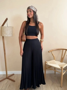 Detail of high-waist pleated wide-leg trousers and cropped tank top in black two-piece set