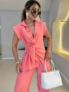 Détail de la chemise rose corail à manches courtes avec nœud à la taille et pantalon décontracté