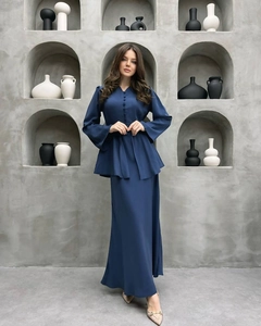 Dettaglio dell'abito blu navy con scollo a V, tessuto liscio e chiusura a bottoni