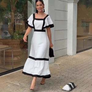 Detail of elegant white square neck midi dress with black contrast piping and ruffled sleeves