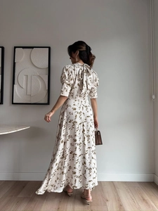 Detail of elegant satin floral dress with puff sleeves and tie-back bow ribbon
