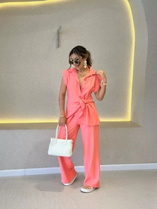Détail d'un ensemble deux pièces corail avec chemise à nouer et pantalon large fluide