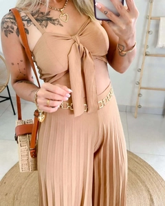 Detail of camel two-piece set featuring front-tie crop top and high-waisted pleated trousers