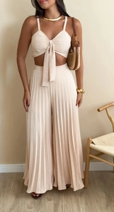 Detail view of beige two-piece set featuring lace-up camisole and pleated wide-leg trousers