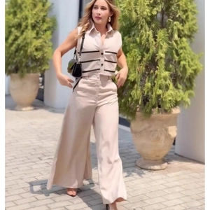 Detail of beige sleeveless crop top with black stripes and matching wide-leg pants set