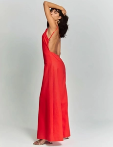 Detail of red backless wide-leg jumpsuit with thin halter straps and glossy finish