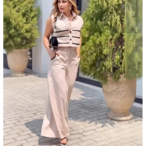 Detail of high-waist wide-leg pants paired with sleeveless contrast stripe top in beige