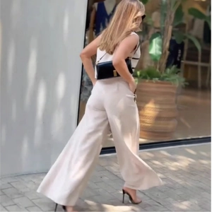 Close-up of high-waist wide-leg trousers in beige fabric with elegant draped texture