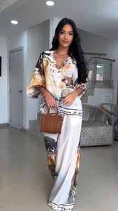 Detail of floral print shirt and wide-leg trousers set with watercolor landscape patterns