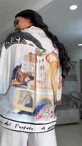 Detail of artistic Mediterranean print and lettering on back of white holiday shirt