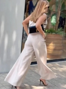 Chic two-piece set featuring contrast sleeveless top and beige high-waisted wide-leg trousers