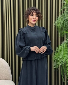 Detail of elegant black dress with ruffle trim standing collar and lantern sleeves