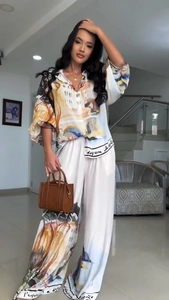 Detail of artistic landscape oil painting print on silky high-waisted wide-leg trousers