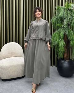 Detail view of a green two-piece skirt set with ruffled blouse and elegant long skirt