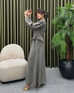 Detail of grey long sleeve top with ruffle hem and matching ankle length skirt