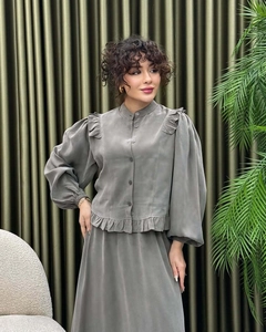 Detailed close-up of dark olive satin two-piece set with ruffled collar and lantern sleeves