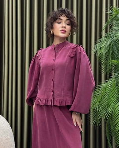 Close-up of elegant plum silk lantern sleeve blouse with high neck and ruffle details