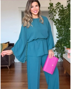 Detail of teal long sleeve top with sequined flare sleeves and matching belt